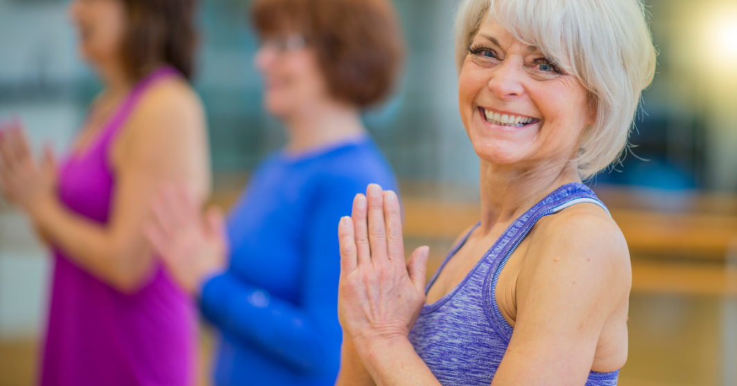 Woman in a yoga class with blurred participants in the background