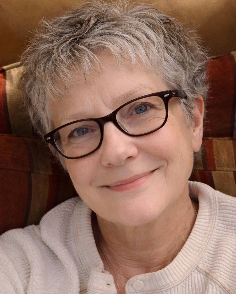 Melinda Gaye Johnston of Buddhi Institute sitting on a striped couch