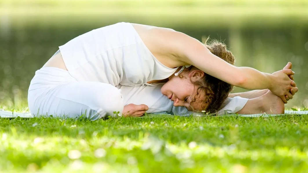 Woman in yoga pose on grass